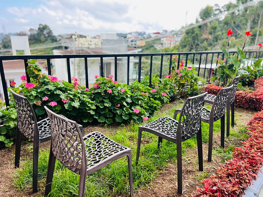 Balcony seating with the geraniums and the valley beyond