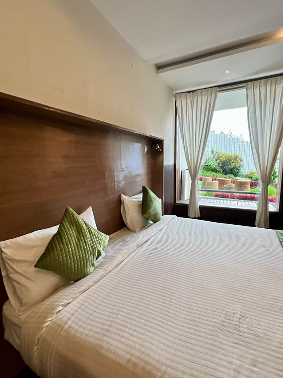 Standard Room bed with garden-view window